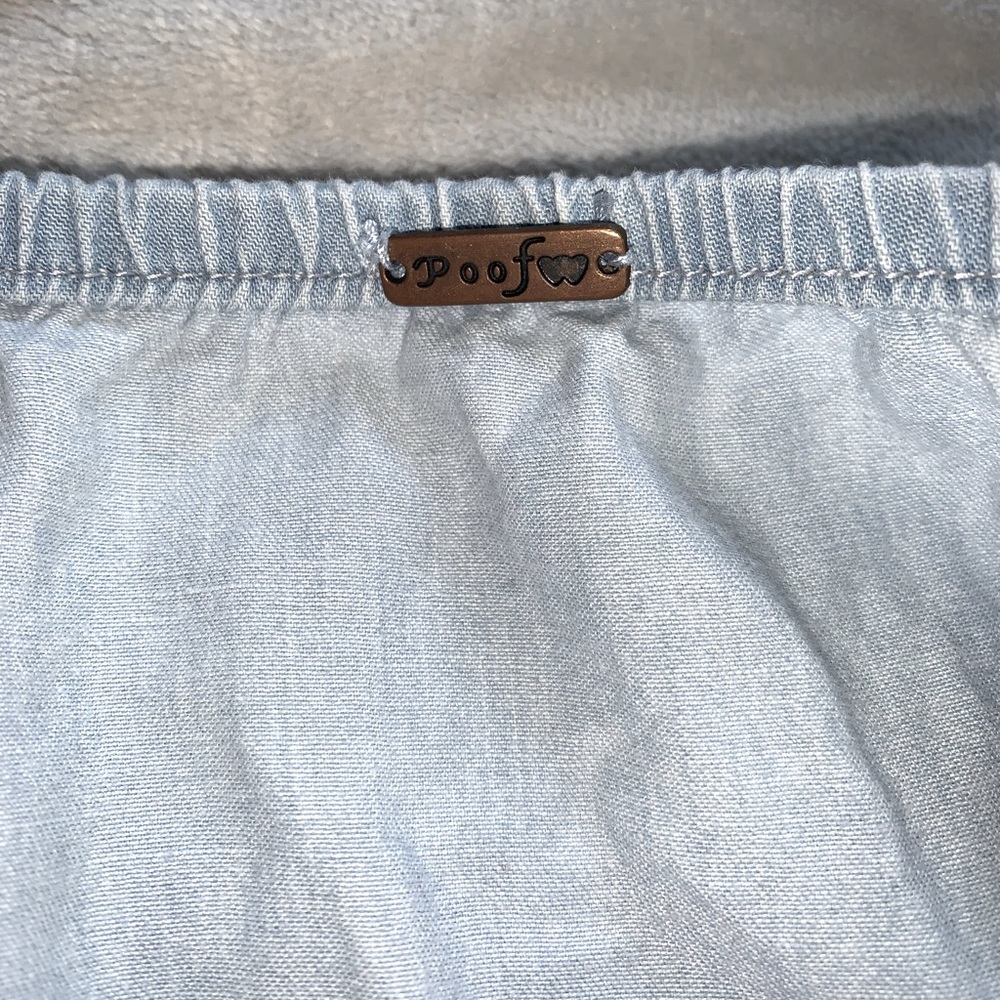 This is a denim blue off the shoulder shirt, size medium, from the brand poof.